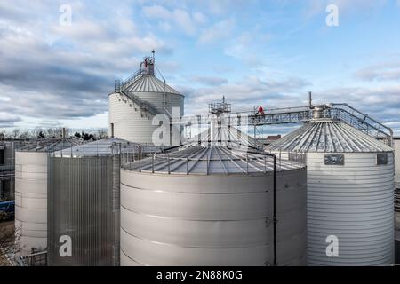 A row of large scale, industrial storage tanks or silos at a chemical plant with copy space above Stock Photo