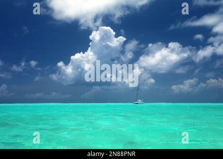 Sailing yacht in turquoise ocean at anchor off the beautiful tropical island of Bora Bora, French Polynesia. Stock Photo