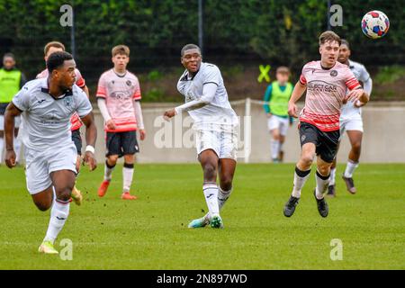 Swansea, Wales. 4 February 2023. Richard Faakye of Swansea City holds off  the challenge from Jack Howland of Millwall during the Professional  Development League game between Swansea City Under 18 and Millwall