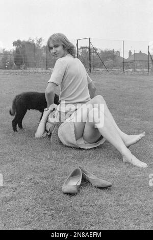 young couple man woman laying in public park on the freshly cut grass enjoying relaxing warm summer day 1980s england uk Stock Photo