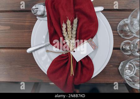Beautiful table setting with plates, glasses on a wooden table Stock Photo