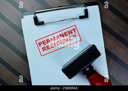 Concept of Red Handle Rubber Stamper and Permanent Residency text isolated on on Wooden Table. Stock Photo