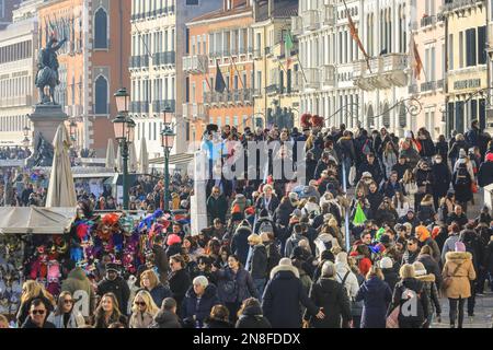Venice, Italy. 11th Feb, 2023. The tightly packed Riva degli Schiavoni on the waterfront. Packed streets, boulevards and bridges can be seen in the central areas of Venice for the carnival 2023, the first year that full festivities are returning after covid. In the afternoon, local police were estimating that around eighty thousand revellers, visitors and locals were packed into the area around St Mark's Square alone. Venice was basking in beautiful sunshine today, which may have attracted even more people to join in. Credit: Imageplotter/Alamy Live News Stock Photo