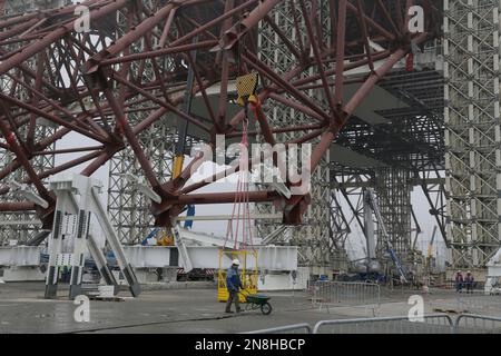 Construction workers assist in the assembly of a gigantic steel-arch to ...