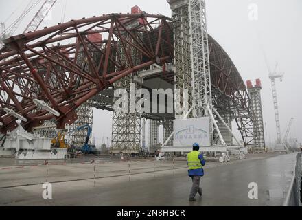 Construction workers assist in the assembly of a gigantic steel-arch to ...