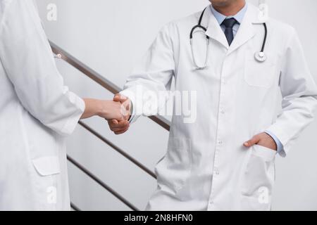 Doctors greeting with handshake in clinic, closeup Stock Photo