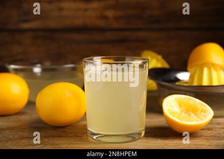 Freshly squeezed lemon juice on wooden table Stock Photo