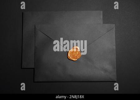 Envelopes with wax seal on black background, top view Stock Photo