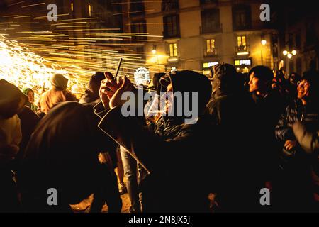 Barcelona, Spain. 11th Feb, 2023. Tourist taking photos dance under fireworks during the 'Correfocs' (fire-runs) at Barcelona's winter city festival 'Santa Eulalia' 2023 Credit: Matthias Oesterle/Alamy Live News Stock Photo