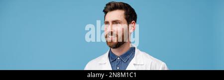 Portrait of handsome professional doctor looking away standing over blue studio background Stock Photo