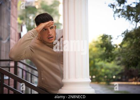 Jealous Man Spying On Ex Girlfriend In Outdoor Cafe Stock Photo - Alamy