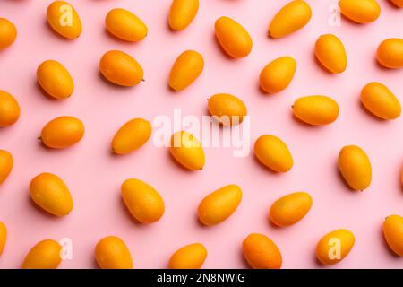 Fresh ripe kumquats on pink background, flat lay Stock Photo