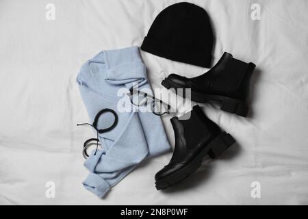 Stylish look with cashmere sweater, flat lay. Women's clothes and accessories on fabric Stock Photo