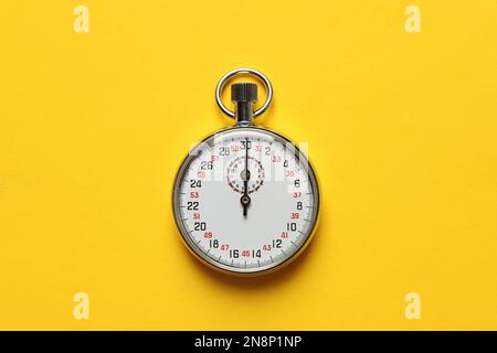 Vintage stopwatch on yellow background, top view Stock Photo