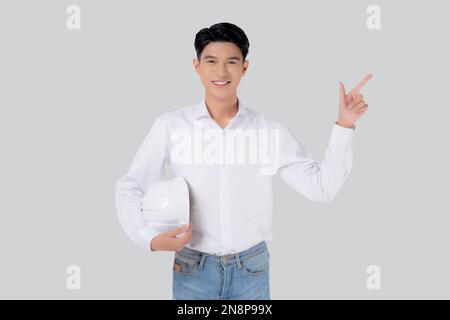Portrait young asian man is engineer holding helmet standing and smiling with confident isolated white background, male is architect or contractor pre Stock Photo