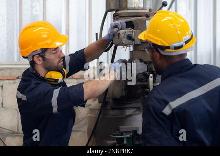 Engineer man training with foreman for apprentice using lathe, apprenticeship teaching with worker, technician and learning, inspector and labor, inte Stock Photo