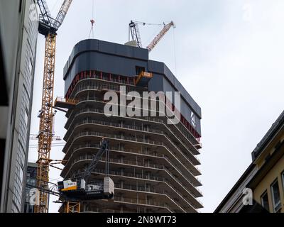 FOUR Skyscraper construction site in the banking district. Tall raw building structure with tower cranes and other equipment. Development of the town. Stock Photo