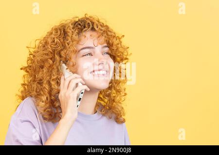 Happy woman with curly hair talking to the mobile Stock Photo