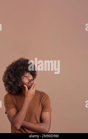African man with hand on face and thoughtful expression Stock Photo