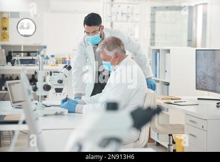 Science is all about extensive work. two scientists working together in a lab. Stock Photo