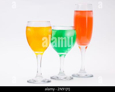 Three glasses with different liquors on white background. Stock Photo