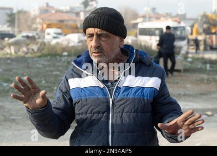 Antakya, Turkey. 11th Feb, 2023. Metin Yalman stands in front of a destroyed house in Antakya. In the rubble lies the body of his 25-year-old son. Thousands of victims are still presumed to be trapped under the rubble. Teams of helpers from all over the world are working in the disaster area. (To dpa 'Waiting for death' from 12.02.2023) Credit: Boris Roessler/dpa/Alamy Live News Stock Photo