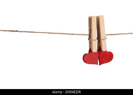 Clothes pegs and two red hearts on rope isolated on white background Valentines day concept Stock Photo