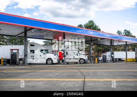 Industrial standard big rigs semi trucks with semi trailers standing on ...