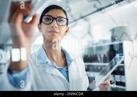 The formula for a no-fail life. a young scientist solving equations on a glass screen in a laboratory. Stock Photo