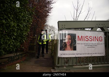 Police officers walk towards a missing person appeal poster for Nicola Bulley on a bridge over the River Wyre in St Michael's on Wyre, Lancashire, as police continue their search for missing woman Nicola Bulley, 45, who was last seen on the morning of Friday January 27, when she was spotted walking her dog on a footpath by the nearby River Wyre. Picture date: Sunday February 12, 2023. Stock Photo