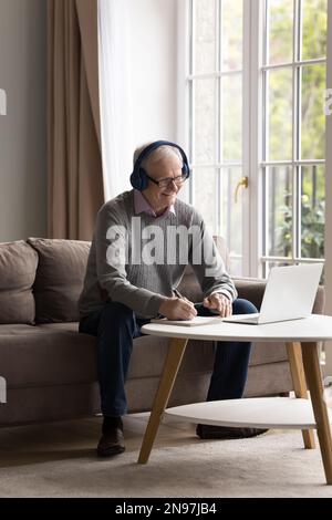 Cheerful older retired man wearing wireless headphones Stock Photo