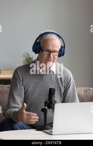 Serious mature influencer recording speech for blog Stock Photo