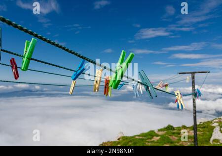Colorful clothespins on the rope high in the mountains. Alpine laundry. Stock Photo