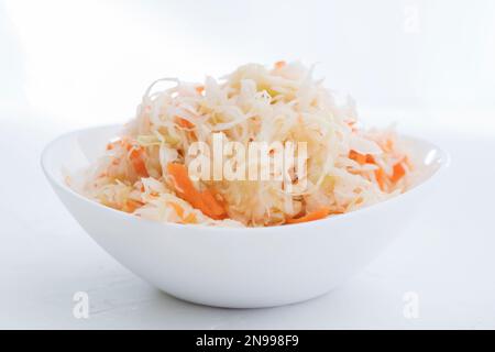 Sauerkraut in a white plate. Homemade sauerkraut with carrot . Fermented food. Natural probiotic. Copy space for text Stock Photo