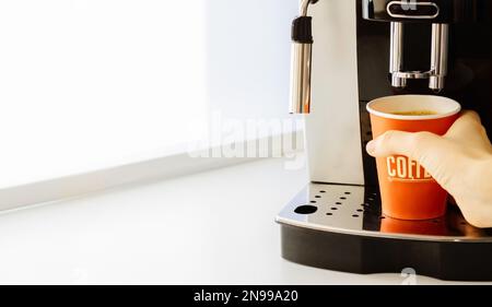 Pouring coffee stream from professional machine in cup. Barista