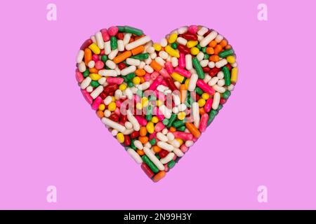 Heart shaped colorful rainbow sprinkles isolated on pink background with clipping path Stock Photo