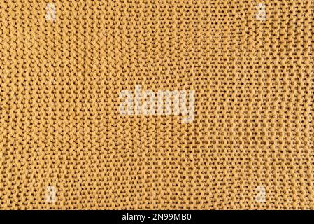 close-up of gold colored knitted fabric, textile background Stock Photo