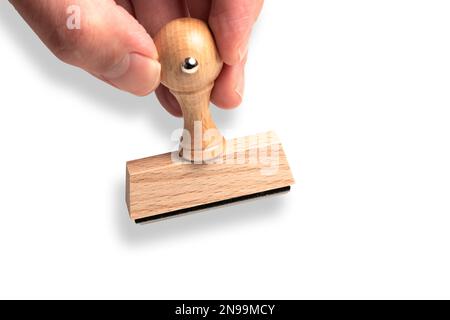 close-up of hand holding wooden rubber stamp against white background template Stock Photo