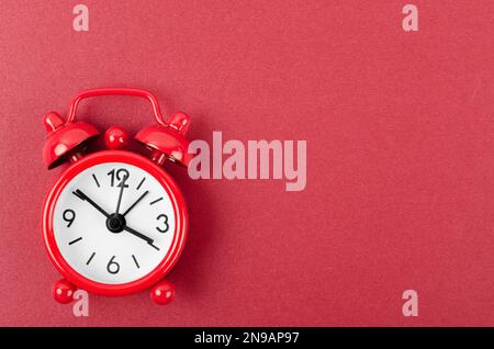 Red alarm clock on red colour background. Stock Photo