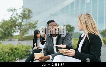 Happy business people having a lunch break outside office Stock Photo