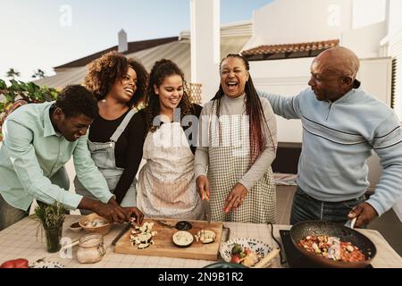 Happy African family preparing food recipe together on house patio Stock Photo