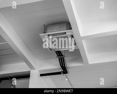 Ceiling mounted cassette type air conditioner decoration near the lights on white concrete construction building, loft style interior. Ceiling type of Stock Photo