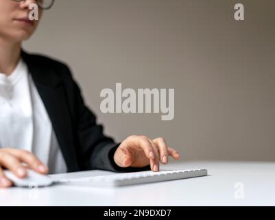 Female business person press keyboard button and using computer mouse. Stock Photo
