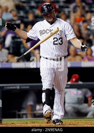 Colorado Rockies pinch hitter Jason Giambi (23) high fives teammate Todd  Helton after scoring against the Philadelphia Phillies in the eighth inning  during game four of the National League Divisional Series at