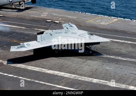 A U.S. Navy X-47B Unmanned Combat Air System makes an arrested landing aboard the aircraft carrier USS George H.W. Bush (CVN 77) The successful landing marks the first time a tail-less, unmanned autonomous aircraft landed on a modern aircraft carrier. Stock Photo