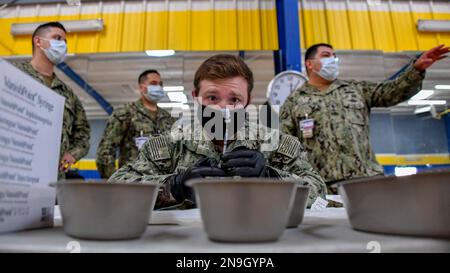 Hospital Corpsman 2nd Class Shane Miller, assigned to Fleet Surgical Team 9, prepares COVID-19 vaccine Stock Photo
