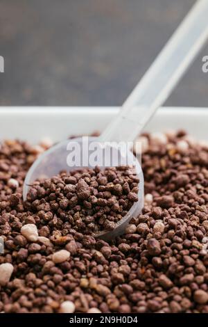Organic NPK fertiliser for herbs and seedlings with a measuring spoon Stock Photo