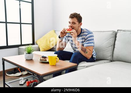 Young hispanic man having breakfast at home Stock Photo