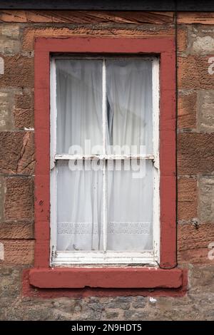 Detail of an old run down window with closed curtains, UK Stock Photo
