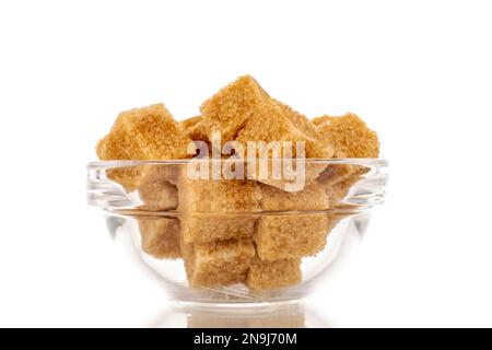 A few cubes of brown sugar in a glass dish, macro, isolated on a white background. Stock Photo